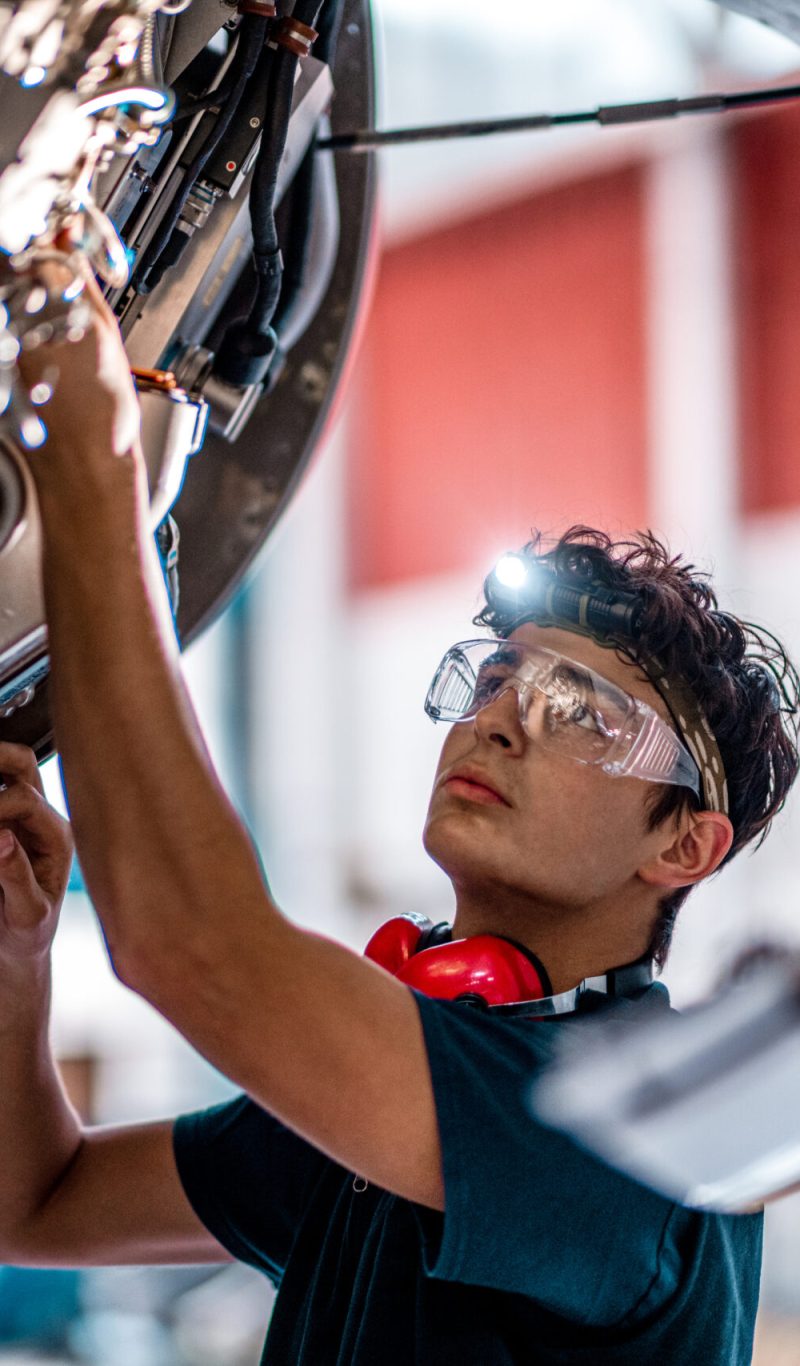 Aircraft mechanic inspecting and checking the technology of a jet engine in the hangar at the airport.